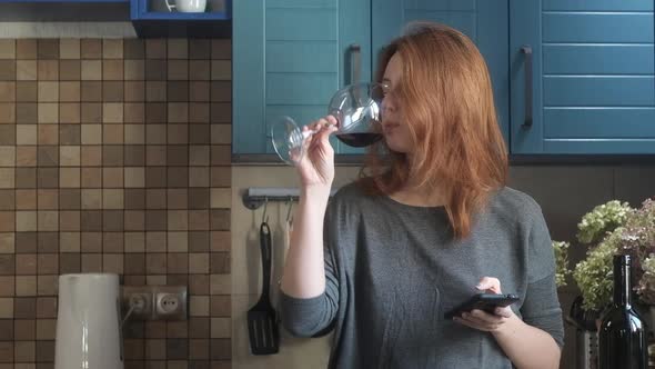 girl enjoys drinking wine from glass and texting phone.