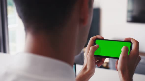 Rare Close-up of the Unrecognizable Man Holding Green Screen Smartphone in Landscape Mode and