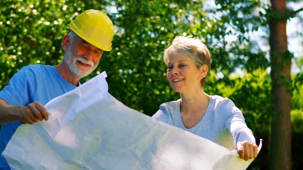 Senior couple looking at map in garden