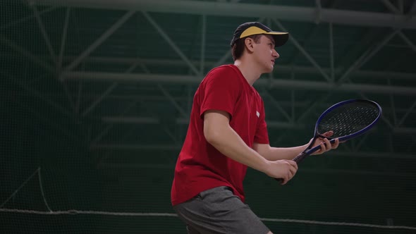 Active Male Tennis Player is Repeling Opponent Attack Hitting Ball By Racquet on Indoor Court