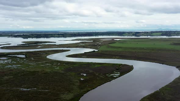 AERIAL Truck Left Over Lake Estuary Spilling Out To A Winding River