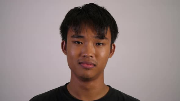 Asian young sad man looks on the camera