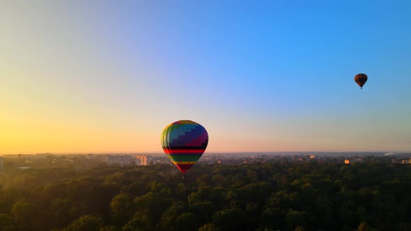 Aerial Drone HDR View of Colorful Hot Air Balloon Flying Over Green Park in Small European City at