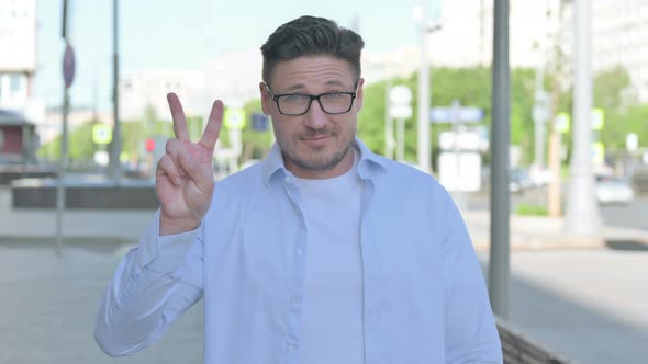 Excited Man Showing Victory Sign Outdoor