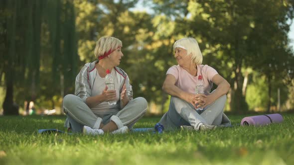 Middle Age Woman and Her Mother Talking After Doing Exercises and Yoga in Park