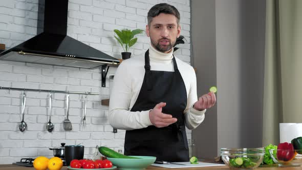Man chef food teacher sliced cucumber in kitchen teaches online videocall webcam