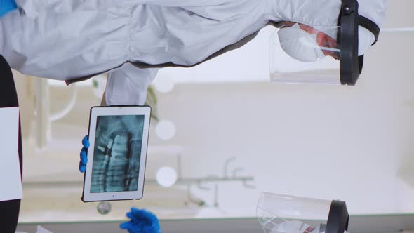 Doctors with Coverall Studying Digital Xray in Waiting Area