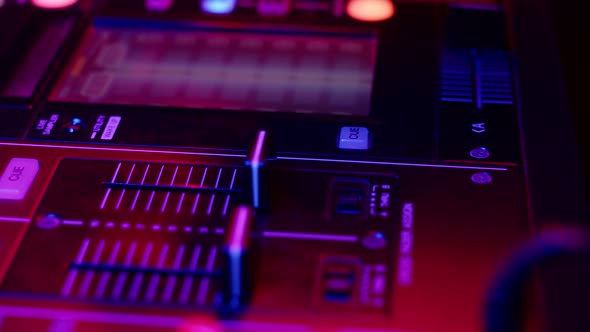 DJ Hand Presses Button and Moves Fader on Mixer Console in Disco Club Closeup