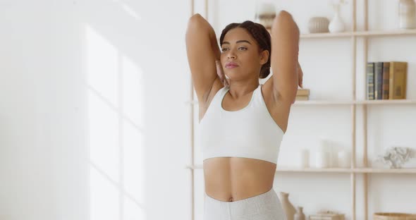 Concentrated African American Lady in Sportswear Twisting Her Shoulders at Home, Slow Motion