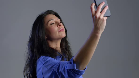 Smiling Happy Adult Woman Making Selfie on Smartphone Over Grey Background. Technology