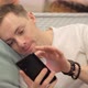 Man Looking at Photos on the Phone While Lying on the Couch - VideoHive Item for Sale