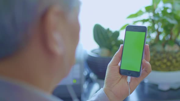 Grandfather Who Makes Video Calls On His Smartphone (Green Screen)