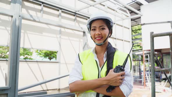 Portrait of Asian woman worker people wear protective safety helmet work wear onsite of architecture