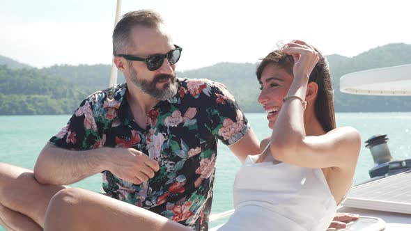 4K Caucasian couple travel on catamaran boat sailing in the sea on summer vacation