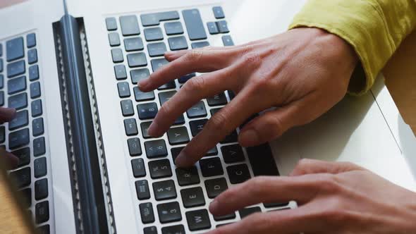 Midsection of caucasian woman using laptop and working from home