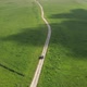 Top view on the driving car of the mountain road through the green field - VideoHive Item for Sale
