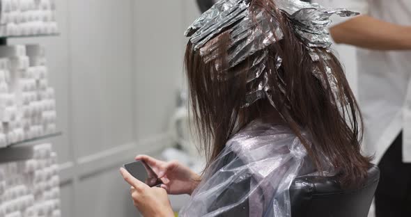 Stylist hairdresser makes hair coloring