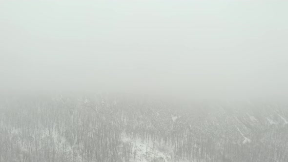 Mountain top in heavy fog by winter 4K drone video