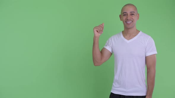 Happy Handsome Bald Man Snapping Fingers and Presenting Something