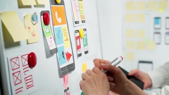 Web designers develop app sketches with a smartphone.