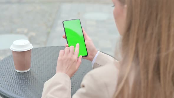 Rear View of Young Businesswoman Using Smartphone with Green Chroma Screen