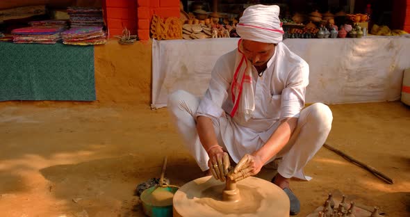 Skilled Professional Potter Throwing the Potter's Wheel and Shaping Traditional Ceramic Vessel and