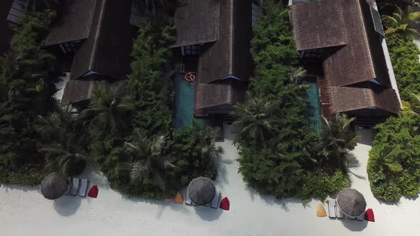 Tropical zoom in drone shot of a pool in a villa on a Maldives island 4K