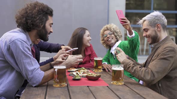 Group of Happy Multi Ethnic Friends with Smartphones Taking Picture of Food and Drink and Selfies