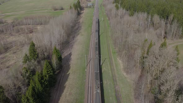 Passenger Train Going Through Spring Fields and Forest Aerial View