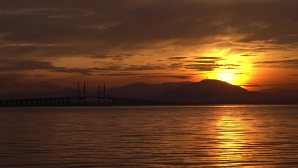 Water gentle flow at the sea in orange sunrise.