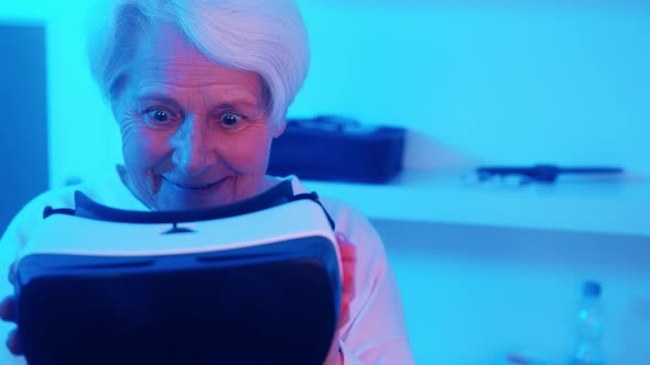 Surprised Elderly Woman Looking at VR Headset and Putting It on