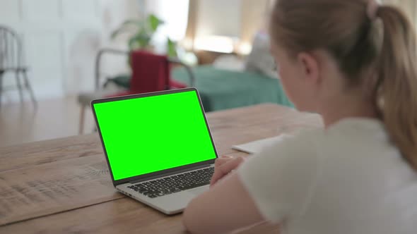 Rear View of Beautiful Woman Working on Laptop with Green Chroma Screen