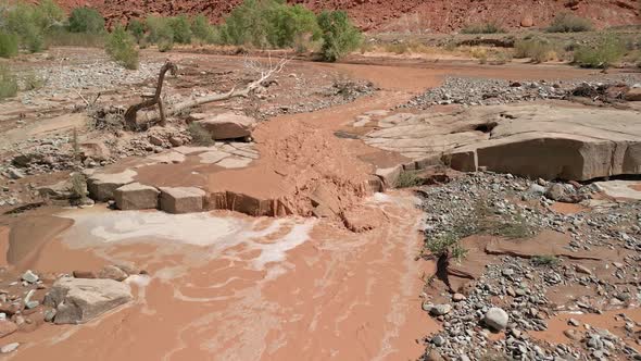 Flying over muddy river flowing after rainstorm in the Utah desert