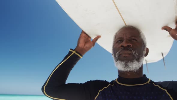 Senior man with a surfboard at the beach