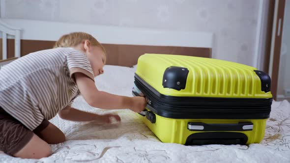 Kids Travel, Merry Little Child Having Fun Playing with Luggage for Vacation Full of Things for