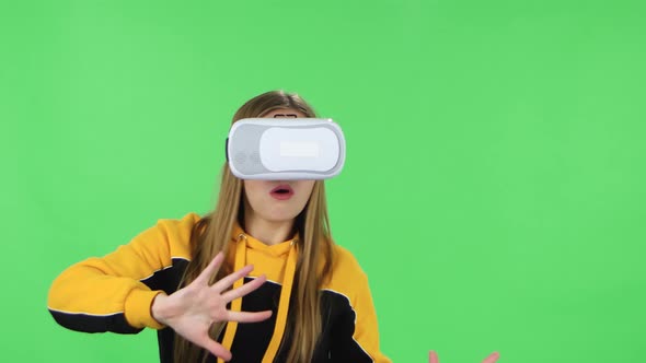 Portrait of Modern Girl in Yellow Hoodie with Virtual Reality Headset or 3D Glasses