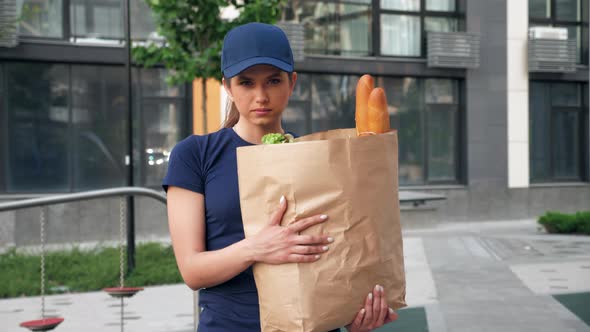 Portrait Serious Food Delivery Woman Courier Holds Paper Bag with Groceries