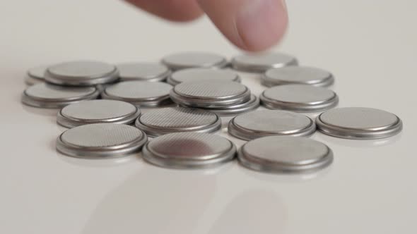 Testing one from lot of button batteries close-up 4K video