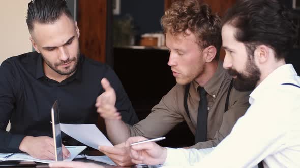 Portrait Of Three Businessmen Having Meeting In a Cafe