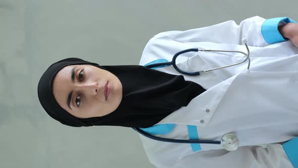 A Woman in a Black Hijab Medical Overalls and with a Stethoscope Around Her Neck is Standing in a