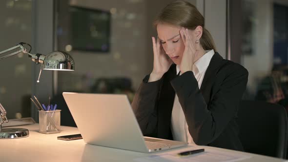 Businesswoman Having Headache While Working on Laptop at Night 