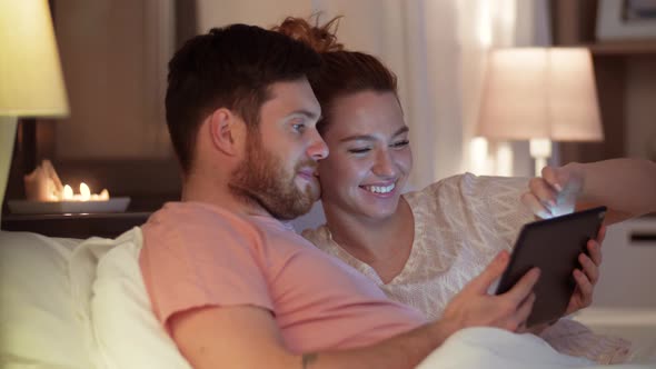 Happy Couple Using Tablet Computer in Bed at Night 61