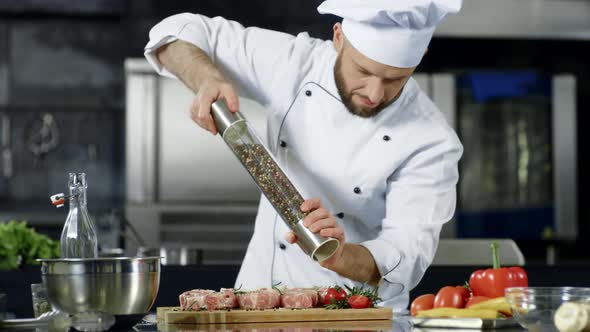 Male Chef Cooking Meat at Professional Kitchen. Portrait of Chef Cooking Steak.