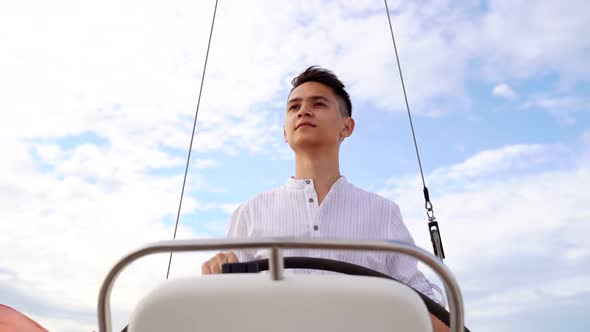 Young Captain at the Helm of the Sailboat