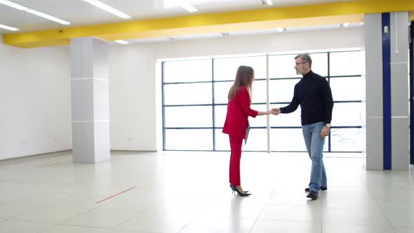 Businesswoman meets with real estate agent with man for business conversation about renting office