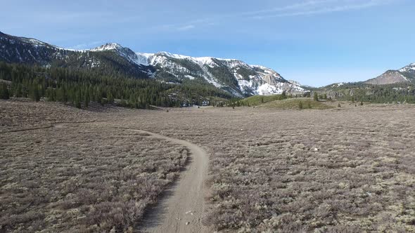 Aerial shot of young woman trail running in the mountains.