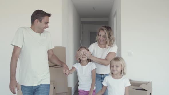 Joyful Parents and Sister Leading Girl with Closed Eyes