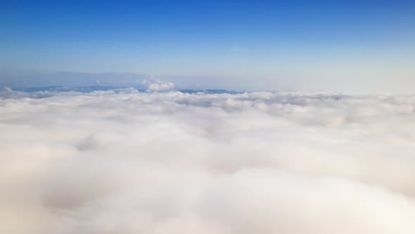 Drone flight over the clouds during sunrise.