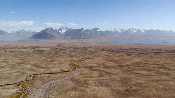 Top Aerial View of Tajikistan Landscape Alpine Blue Lake and Gravel Arid Desert Mountains in Sunny