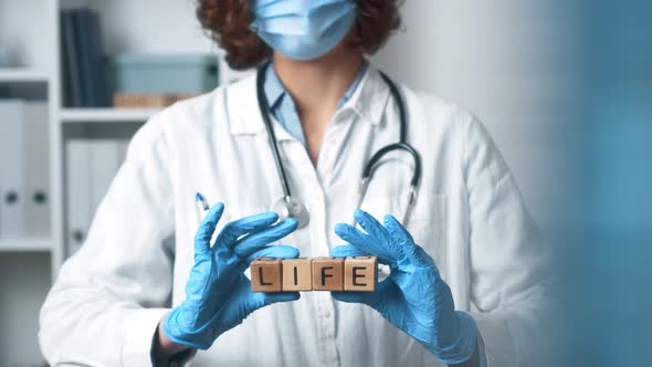 Doctor Holds Word Life In Hands. Health Care, Life, Medicine. Young Female Doctor In Medical Coat